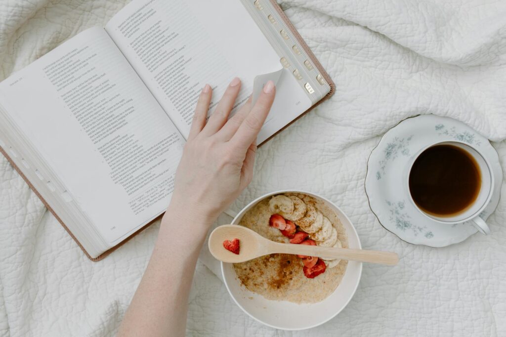 a person having breakfast while reading a book